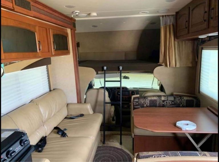 Looking forward through the RV: sofa, dinette and cab-over bed